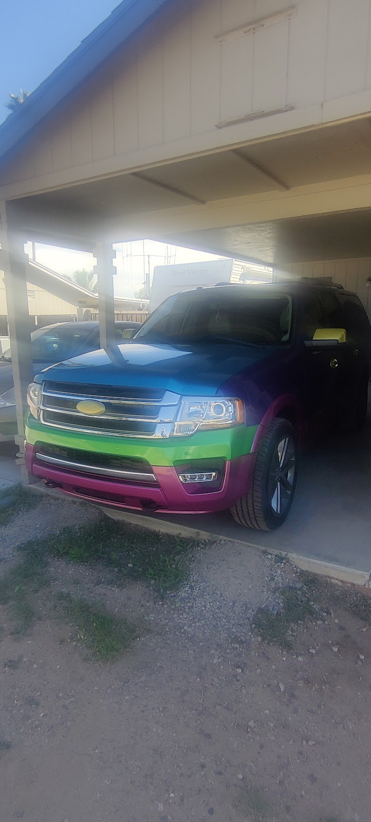 Ford Expedition with a color-shift wrap parked under a customer's carport